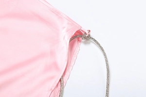 Detail of pink satin evening dress with sparkling rhinestone shoulder strap detail
