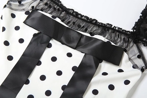 Detail of the black polka dot dress with lace trim and elegant satin bow