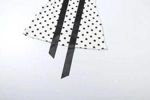 Detailed macro shot of white polka dot fabric with elegant black satin ribbon ties