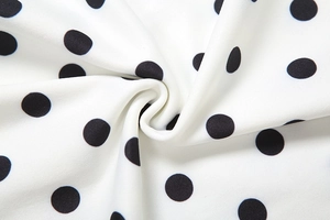 Detail shot of the black and white polka dot fabric texture with smooth soft folds