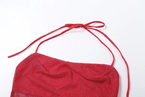 Detail eines roten Neckholder-Tops mit Pailletten, Metallglanz und Bindebändern