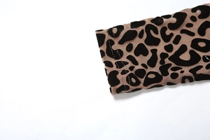 Detail of leopard print mesh sleeve with black flocked spots and double-needle stitching