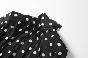 Detail of high neck ruched collar on polka dot dress with semi-transparent mesh fabric