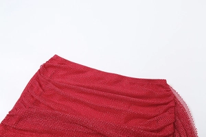 Detail aus rotem Netzstoff mit funkelnden Strasssteinen und eleganten Drapierungen