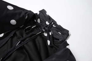 Detailed macro view of black polka dot fabric with drawstrings and fine stitching