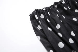 Detailed view of elastic smocked top edge on polka dot dress with sheer fabric texture