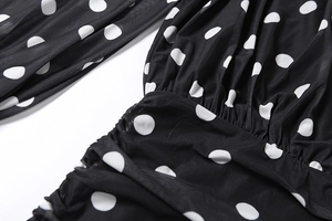 Detail showing white polka dot pattern on black fabric with elegant shirring texture