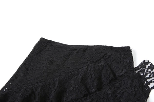 Close-up of intricate black floral lace pattern and hollow mesh texture on a mini skirt