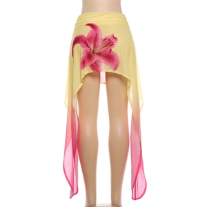 Detail of floral printed asymmetric skirt with pink lily pattern and gradient hemline