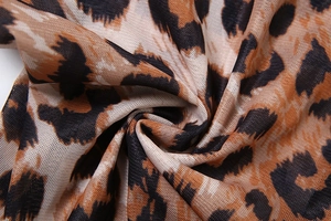Macro shot of breathable leopard print mesh fabric with soft sheer texture and leopard pattern