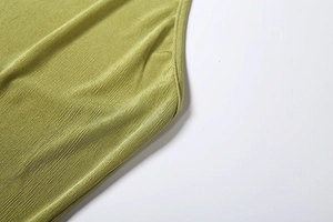 Macro shot of lime green pleated fabric with fine vertical texture and premium stitching