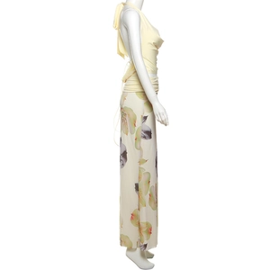 Detail of light yellow halter top with draped neck and floral print long skirt set