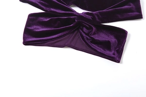 Detail aus lila Samtstoff mit gedrehtem Knoten und symmetrischem Ausschnitt-Design
