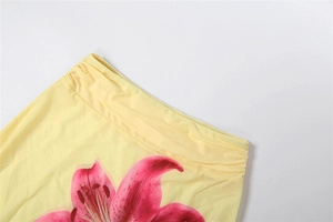 Detail of light yellow floral skirt with pink lily print and elastic pleated waistband