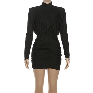 Detalle del tejido fruncido en un vestido corto negro de cuello alto y manga larga