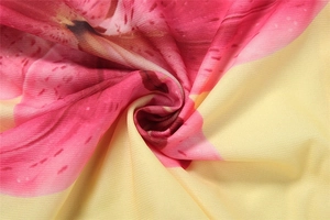 Close-up of lightweight floral chiffon fabric with soft pink flower print on yellow