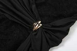Détail de la combinaison en dentelle noire avec boucle en métal doré et tissu plissé