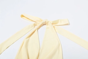 Detail of elegant cream yellow halter neck tie with a sophisticated knotted design