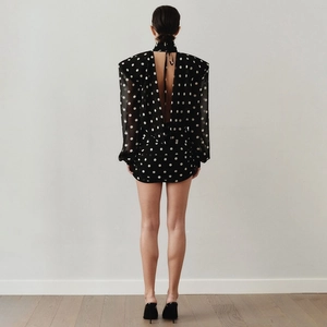 Retro black polka dot mini dress featuring a high neck, open back, and padded shoulders