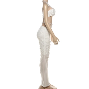 Detail des weißen zweiteiligen Sets mit gerafftem Rock und Perlenbandeau-Oberteil
