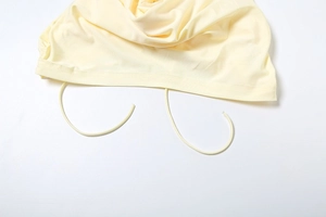 Detail of light yellow knit fabric edge with matching drawstring and smooth stitching