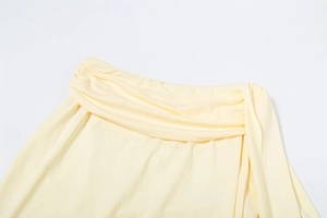 Detailed view of pale yellow knit fabric featuring elegant waist ruching and drape texture