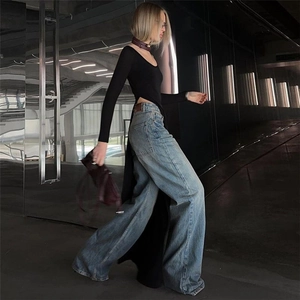 Detail of slim fit long sleeve top with irregular high side slit and round neckline