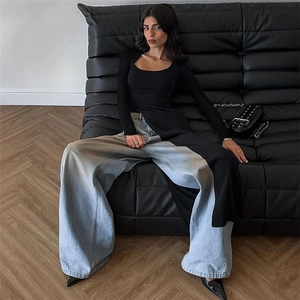 Detail of slim fit long sleeve top with side slit paired with wide leg jeans