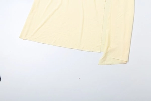 Detailed view of cream yellow knit maxi dress showing side slit and fabric texture