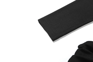 Detalle del vestido de punto negro con puños elásticos y costuras de alta calidad