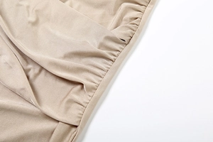 Detailed view of champagne gold satin fabric with elegant pleated texture and silk gloss