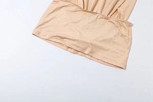 Detailed close-up showing the precise stitching on the hem of a beige bodycon dress