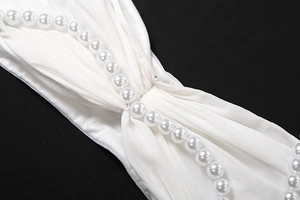 Detailansicht weißer Perlen auf gerafftem Netzstoff des sexy Top und Rock Bekleidungssets