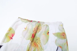 Detailed macro view of orchid floral print on sheer white mesh fabric with fine stitching