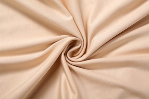 Macro shot of soft champagne bodysuit fabric with elegant silky textures and smooth draping