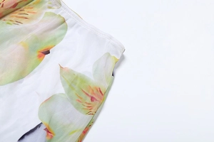 Close-up of floral print fabric with fine stitching and delicate pastel flower patterns