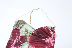 Détail d'une robe fleurie dos nu avec chaîne décorative et bretelles en perles roses