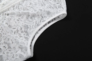 Détail d'une combinaison en dentelle blanche avec broderie florale et texture de maille nette