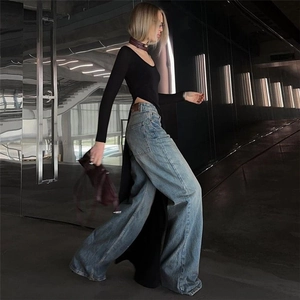 Close-up of high side slit design on black long sleeve slim-fit top with denim jeans