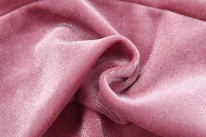 Detaillierte Makroansicht von rosa Samtstoff mit weicher Textur und seidigem Glanz