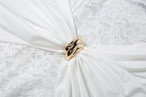 Boucle en métal doré poli à plusieurs couches sur dentelle blanche et tissu en soie