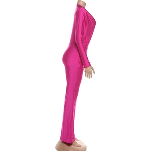 Detail of rose red V-neck jumpsuit showing metallic shine fabric and side ruching texture
