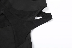 Detail view of black knit top featuring intricate cut-out and layered fabric construction