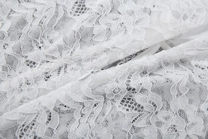 Détail de la dentelle blanche avec texture florale et fermeture éclair invisible