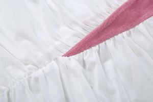 Nahaufnahme von weißem Netzstoff mit rosa Samtbesatz am Bund der Damenbekleidung