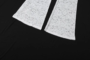 Gros plan détaillé de l'ourlet en dentelle blanche sur un pantalon évasé au motif crochet