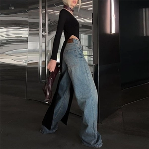 Close-up of slim-fit black long sleeve top with irregular high-split asymmetrical hem