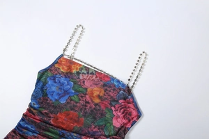Detailed view of vibrant floral print dress with elegant rhinestone chain straps