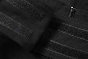 Macro detail of adjustable hook and loop straps and durable metal zipper on a black tactical jacket