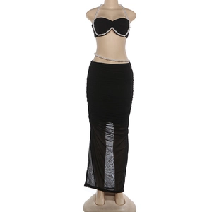 Detail des schwarzen Zweiteilers mit Perlenverzierung an Crop-Top und gerafftem Rock